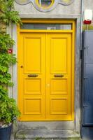 amarillo madera y un antiguo puerta con un gris frente. foto