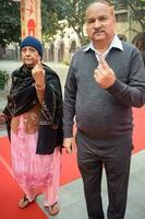 New Delhi, India - March 04 2023 - Unidentified people showing their ink-marked fingers after casting votes in front of polling booth of east Delhi area for MCD local body Elections 2022 photo