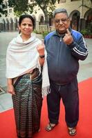 New Delhi, India - March 04 2023 - Unidentified people showing their ink-marked fingers after casting votes in front of polling booth of east Delhi area for MCD local body Elections 2022 photo