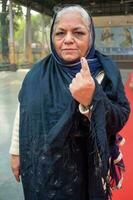 nuevo Delhi, India - marzo 04 2023 - no identificado personas demostración su marcado con tinta dedos después fundición votos en frente de votación cabina de este Delhi zona para mcd local cuerpo elecciones 2022 foto