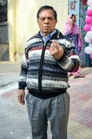 New Delhi, India - March 04 2023 - Unidentified people showing their ink-marked fingers after casting votes in front of polling booth of east Delhi area for MCD local body Elections 2022 photo