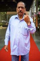 New Delhi, India - March 04 2023 - Unidentified people showing their ink-marked fingers after casting votes in front of polling booth of east Delhi area for MCD local body Elections 2022 photo