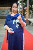 New Delhi, India - March 04 2023 - Unidentified people showing their ink-marked fingers after casting votes in front of polling booth of east Delhi area for MCD local body Elections 2022 photo