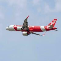New Delhi, India, April 16 2023 - Air Asia Airbus A320 take off from Indra Gandhi International Airport Delhi, Air Asia domestic aeroplane flying in the blue sky during day time photo