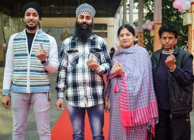 New Delhi, India - May 04 2023 - Unidentified people showing their ink-marked fingers after casting votes in front of polling booth of east Delhi area for MCD local body Elections 2022 photo