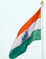 India flag flying high at Connaught Place with pride in blue sky, India flag fluttering, Indian Flag on Independence Day and Republic Day of India, tilt up shot, Waving Indian flag, Har Ghar Tiranga photo