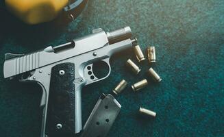 Top view, flat lay of handguns bullets and yellow noise canceling headphones on paper shooting practice target. After shooter practice shooting at theshooting range. Sport shooting concept. photo