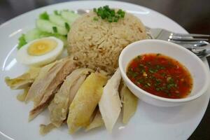 hainés pollo arroz con picante salsa y huevo en el mesa. foto