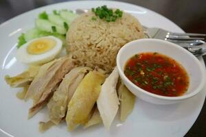 Hainanese chicken rice with spicy sauce and egg on the table. photo