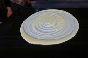 Crepes dough with spiral on black background photo