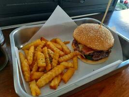 carne de vaca hamburguesa con francés papas fritas en un bandeja en un rápido comida restaurante. foto