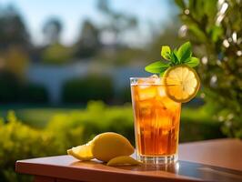 a glass filled with iced tea garnished with fresh lemon slices and mint leaves. Image photo