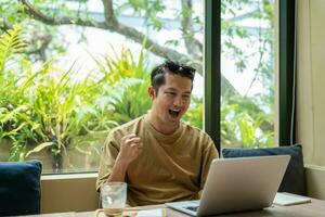 Freelance male sitting working in the cafe and looking outside photo