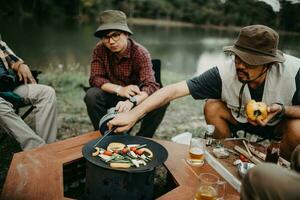 joven hombre Cocinando filete en un cámping viaje foto