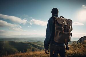 A man with a backpack stands on a mountain top looking at the mountains. photo