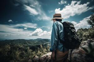 A man with a backpack stands on a mountain top looking at the mountains. photo