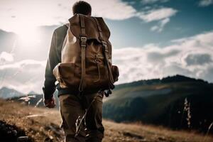 A man with a backpack stands on a mountain top looking at the mountains. photo