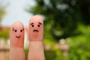 Finger art of couple. Woman is cheerful, man is sad. photo