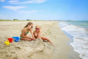 niños jugar con arena en playa. foto