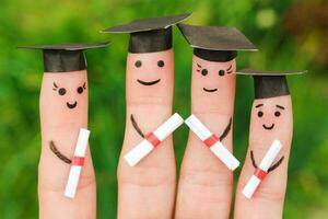 Finger art of students. Graduates holding their diploma after graduation. Toned image photo