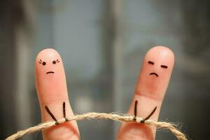 Finger art of couple. Woman and man pull rope. Couple quarreled, cannot solve the problem, a misunderstanding. photo