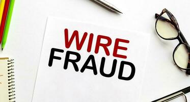 wire fraud on white paper sheet and glasses photo