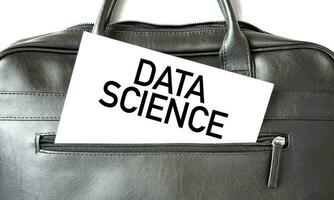 Text DATA SCIENCE writing on white paper sheet in the black business bag. Business concept photo