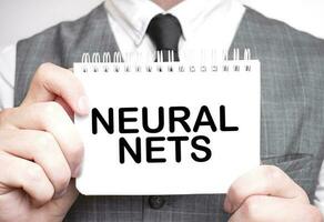 Businessman with notebook with text NEURAL NETS photo