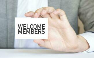 Businessman holding a card with text WELCOME MEMBERS photo