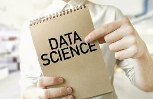 Text DATA SCIENCE on brown paper notepad in businessman hands in office. Business concept photo