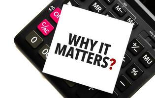 words why it matters on white sticker and calculator on white background photo