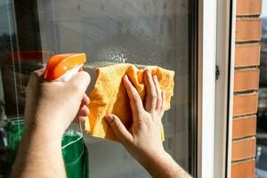 cleaning outdoor window glass with spray and rag photo