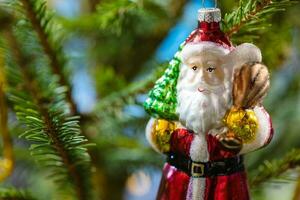 glass santa claus toy on natural christmas tree photo