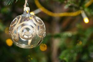 ball with golden pattern on christmas tree closeup photo