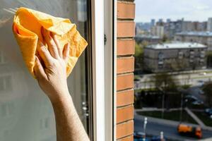 hand wipes open window with rag in city house photo