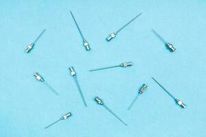 top view of vintage hypodermic needles on blue photo