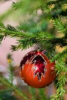red glass ball with leaf image on christmas tree photo