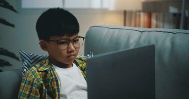 inteligente chico utilizar ordenador portátil computadora a aprendizaje en línea a hogar foto