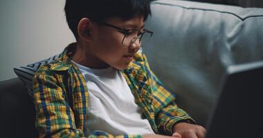 Smart boy use laptop computer to learning online at home photo
