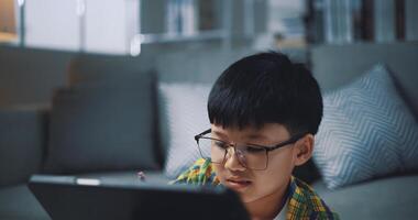 Asian genius boy use tablet doing homework in living room photo