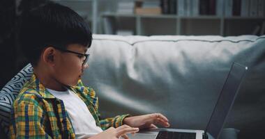 Smart boy use laptop computer to learning online at home photo