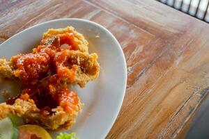 Fried squid with sweet spicy sauce, traditional sea food of Indonesian. The photo is suitable to use for food background, menu poster and content media.