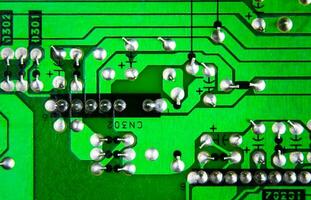 Close up of an green electronic circuit board with industry standard pin soldering, electronics part concept. photo
