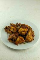 indonesio frito pollo, ayam goreng bubu kuning es un famoso tradicional indonesio frito pollo hecho desde pollo ese es cocido a fuego lento con especias foto