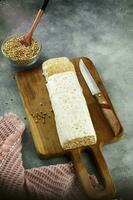 Raw tempeh or tempe, tempeh slices on wooden plate and raw soybean seeds. Tempe is a traditional Indonesian food made from fermented soybeans. photo