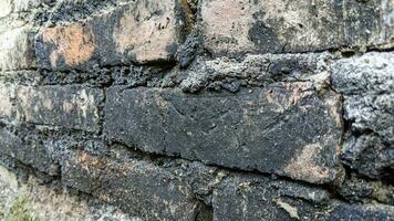blackened texture of brick wall. Dirty red grunge brick wall photo