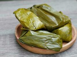 Buras or rice processed food filled with chopped chicken meat. Indonesian traditional food photo