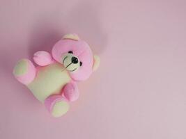 encantador rosado oso muñeca en rosado antecedentes. adorable rosado oso para decorativo. con Copiar espacio para texto foto