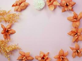 Floral composition. Frame made of orange dry flowers on pastel pink background. Flat lay, top view, copy space photo