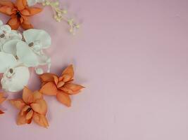 Greeting card background, dry orange and white flowers on pink. Flat lay, top view, copy space photo